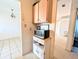 Bright kitchen features white cabinets, microwave, and neutral tile flooring at 5951 Todd St # D37, Bradenton, FL 34207