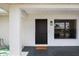 Covered entryway with a sleek black door and contemporary light fixture for curb appeal at 624 Fort Duquesna Dr, Sun City Center, FL 33573