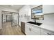 Modern kitchen featuring white cabinets, stainless steel appliances, black faucet, and view of sitting area beyond at 624 Fort Duquesna Dr, Sun City Center, FL 33573