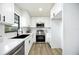 Modern kitchen with white cabinets, stainless steel appliances, black faucet, and a view out of the window at 624 Fort Duquesna Dr, Sun City Center, FL 33573