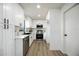 Bright modern kitchen featuring white cabinets, stainless steel appliances and black hardware and faucet, with wood flooring at 624 Fort Duquesna Dr, Sun City Center, FL 33573