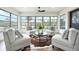 Cozy sitting area with comfortable chairs arranged around a round table on an animal hide rug, framed by large windows at 624 Fort Duquesna Dr, Sun City Center, FL 33573