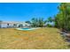 This backyard boasts a beautiful pool, ample green space, and mature trees, providing a serene and inviting outdoor environment at 6698 Acmar Ct, North Port, FL 34287