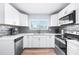 Well-lit kitchen with stainless appliances and white cabinetry at 6698 Acmar Ct, North Port, FL 34287