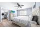 Bright main bedroom featuring a ceiling fan, neutral paint, and ensuite bathroom with modern finishes at 6698 Acmar Ct, North Port, FL 34287