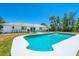 Inviting backyard pool with a sunbathing area, lounge furniture and a well-maintained lawn at 6698 Acmar Ct, North Port, FL 34287
