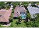 Aerial view of home with tile roof, screened pool and patio, lush landscaping and surrounding neighborhood at 6924 Cumberland Ter, University Park, FL 34201