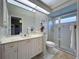 Bright bathroom featuring a glass shower, white cabinets, and a large mirror at 6924 Cumberland Ter, Bradenton, FL 34201
