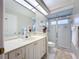 Bright bathroom featuring a glass shower, white cabinets, and a large mirror at 6924 Cumberland Ter, Bradenton, FL 34201