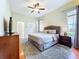 Bedroom with hard wood floors, a king bed, a ceiling fan, and a television at 6924 Cumberland Ter, University Park, FL 34201