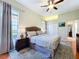 Bedroom with ceiling fan, hard wood floors, a king bed, and large windows at 6924 Cumberland Ter, University Park, FL 34201