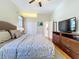 Comfortable bedroom with hardwood floors, a king bed, ceiling fan, and a television at 6924 Cumberland Ter, University Park, FL 34201