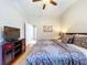 Comfortable bedroom featuring ceiling fan, TV, and a cozy king-size bed with soft carpet at 6924 Cumberland Ter, University Park, FL 34201