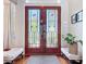 Charming foyer featuring hardwood floors, decoratve glass doors, two benches, a rug, and an indoor plant at 6924 Cumberland Ter, University Park, FL 34201
