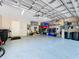 Spacious two-car garage with ample storage space, an epoxy floor, and well-organized shelving systems at 6924 Cumberland Ter, University Park, FL 34201