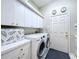 Well-lit laundry room featuring front-load washer and dryer, white cabinets, and neutral wall color at 6924 Cumberland Ter, University Park, FL 34201