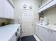 Bright laundry room with white cabinets, modern washer and dryer, and utility sink at 6924 Cumberland Ter, Bradenton, FL 34201