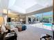 Bright living room with sliding glass doors opening to an outdoor patio and pool, and a large skylight above at 6924 Cumberland Ter, University Park, FL 34201