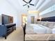 Bedroom with a ceiling fan, tray ceiling, bay window, and large bed covered in luxury bedding at 6924 Cumberland Ter, Bradenton, FL 34201
