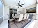Charming outdoor dining area with ceiling fan, stainless steel grill, and ample seating for entertaining at 6924 Cumberland Ter, University Park, FL 34201