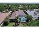 Expansive aerial view of the house with a screened-in pool, surrounded by green lawns and mature trees at 6924 Cumberland Ter, University Park, FL 34201