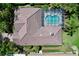 Aerial view of the house highlighting the roof and screened-in pool surrounded by mature landscaping at 6924 Cumberland Ter, University Park, FL 34201