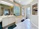 Relaxing bathroom with a garden tub, dual sinks, tile floors and bright window lighting at 6924 Cumberland Ter, University Park, FL 34201