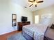 Restful bedroom includes a ceiling fan, television, wood flooring and ensuite bathroom access at 6924 Cumberland Ter, University Park, FL 34201