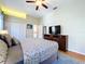 Relaxing bedroom with a ceiling fan, television, and wood flooring provides a peaceful personal retreat at 6924 Cumberland Ter, University Park, FL 34201