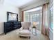 Cozy sitting area featuring a cushioned chair, bay window, dresser and large mirror for comfortable living at 6924 Cumberland Ter, University Park, FL 34201