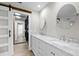 Bathroom featuring dual sinks, marble countertops and a sliding barn door at 7016 Dusty Rd, Riverview, FL 33569