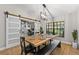 Stylish dining room with a unique wooden table, modern chandelier, and view of the office at 7016 Dusty Rd, Riverview, FL 33569
