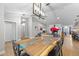 Open dining area with a live-edge wood table, modern lighting, and connection to the living room at 7016 Dusty Rd, Riverview, FL 33569