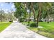 Long driveway leading to the house and detached garage, surrounded by landscaped yard with mature trees at 7016 Dusty Rd, Riverview, FL 33569