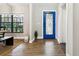 Inviting foyer featuring a bright blue front door with decorative details and hardwood flooring at 7016 Dusty Rd, Riverview, FL 33569