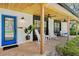 Inviting front porch with brick flooring, ceiling fans, rocking chairs, and a bright blue front door at 7016 Dusty Rd, Riverview, FL 33569