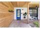 Charming front porch featuring wood accents, a vibrant blue door, and comfortable rocking chairs at 7016 Dusty Rd, Riverview, FL 33569