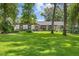 Charming single-story home featuring lush green lawn and mature trees enhancing curb appeal at 7016 Dusty Rd, Riverview, FL 33569