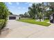Driveway and large backyard featuring detached garage and outdoor fire pit with chairs at 7016 Dusty Rd, Riverview, FL 33569