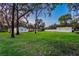 Dusk shot of large backyard featuring the home, a detached garage, and fire pit area at 7016 Dusty Rd, Riverview, FL 33569