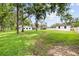 Wide shot of the expansive backyard with detached garage, home, and fire pit area at 7016 Dusty Rd, Riverview, FL 33569