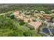 An aerial view showcases a home's tile roof, screened pool, landscaping and location within a tree-lined neighborhood at 7659 Trillium Blvd, Sarasota, FL 34241