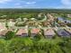 Aerial view of single-story home with screened-in pool in a lushly landscaped neighborhood at 7659 Trillium Blvd, Sarasota, FL 34241