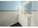 This bathroom features a white sink and vanity, along with white walls, black floors, and stainless steel hardware at 7659 Trillium Blvd, Sarasota, FL 34241