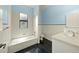 This bathroom features black floors, white walls, a shower-tub combo, and a sink with a white vanity at 7659 Trillium Blvd, Sarasota, FL 34241