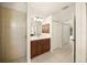 Bathroom featuring a white vanity and tiled walk-in shower with a glimpse of a carpeted bedroom at 7659 Trillium Blvd, Sarasota, FL 34241