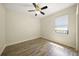 Neutral colored bedroom with ceiling fan, hardwood floors, and a window letting in lots of sunlight at 7659 Trillium Blvd, Sarasota, FL 34241