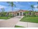 Beautiful single-story home featuring a tile roof, arched windows, manicured landscaping, and a brick driveway at 7659 Trillium Blvd, Sarasota, FL 34241
