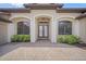 Elegant front entrance with arched windows, beautiful landscaping, and a brick paver walkway, adding curb appeal at 7659 Trillium Blvd, Sarasota, FL 34241