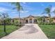 Beautiful home featuring a paver driveway, manicured lawn, and elegant landscaping, providing great curb appeal at 7659 Trillium Blvd, Sarasota, FL 34241
